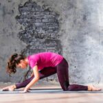 slim-fitness-young-woman-practicing-yoga-against-grey-damaged-wall_23-2147941356